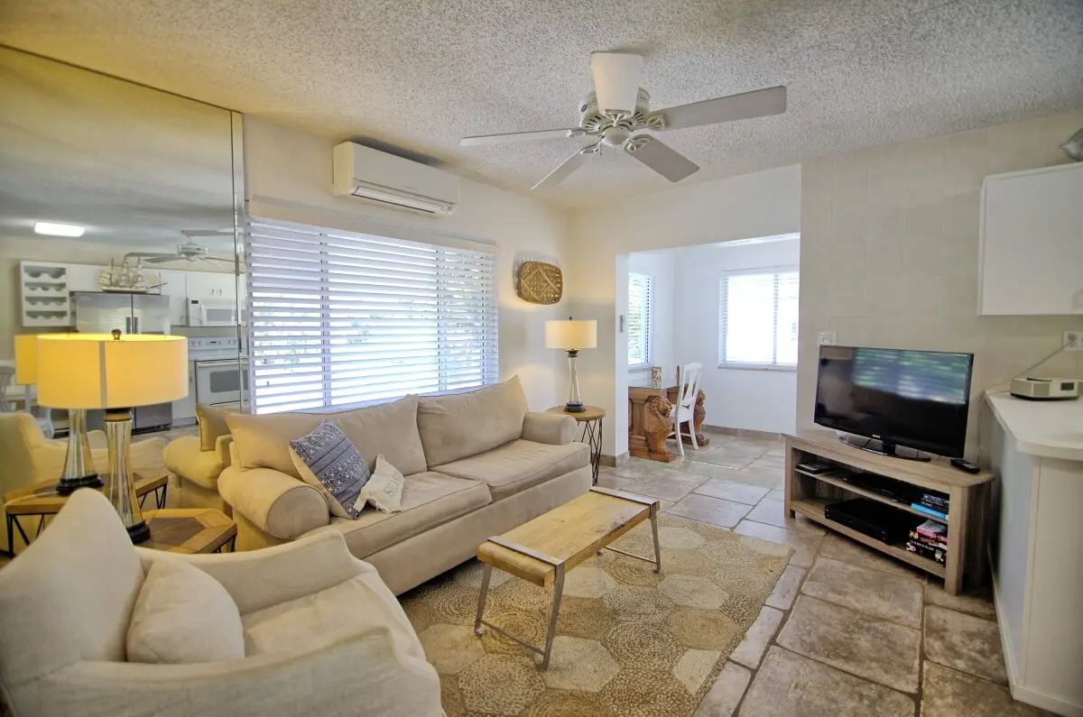 A living room with a couch, chair and television.